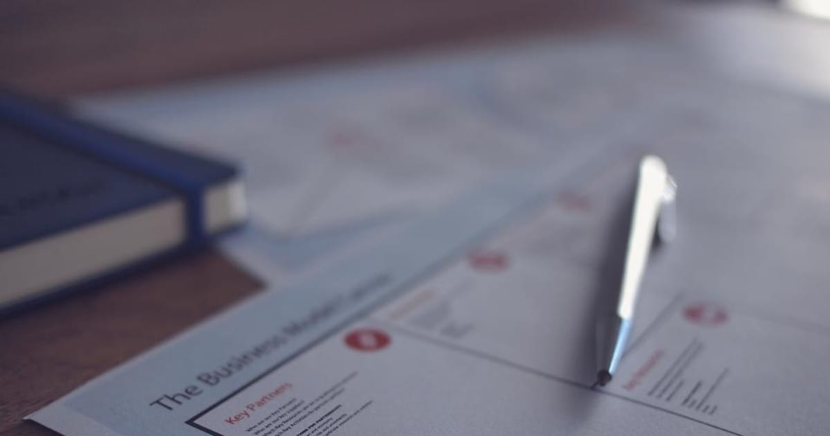 A printed business document with annotations and a pen on a desk